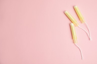 Photo of Tampons on light pink background, flat lay. Space for text