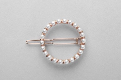 Photo of Elegant pearl hair clip on white background, top view