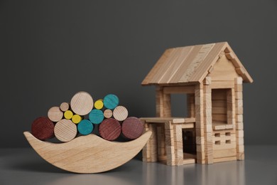 Wooden balance toy and house on table near dark grey wall, closeup. Children's toys