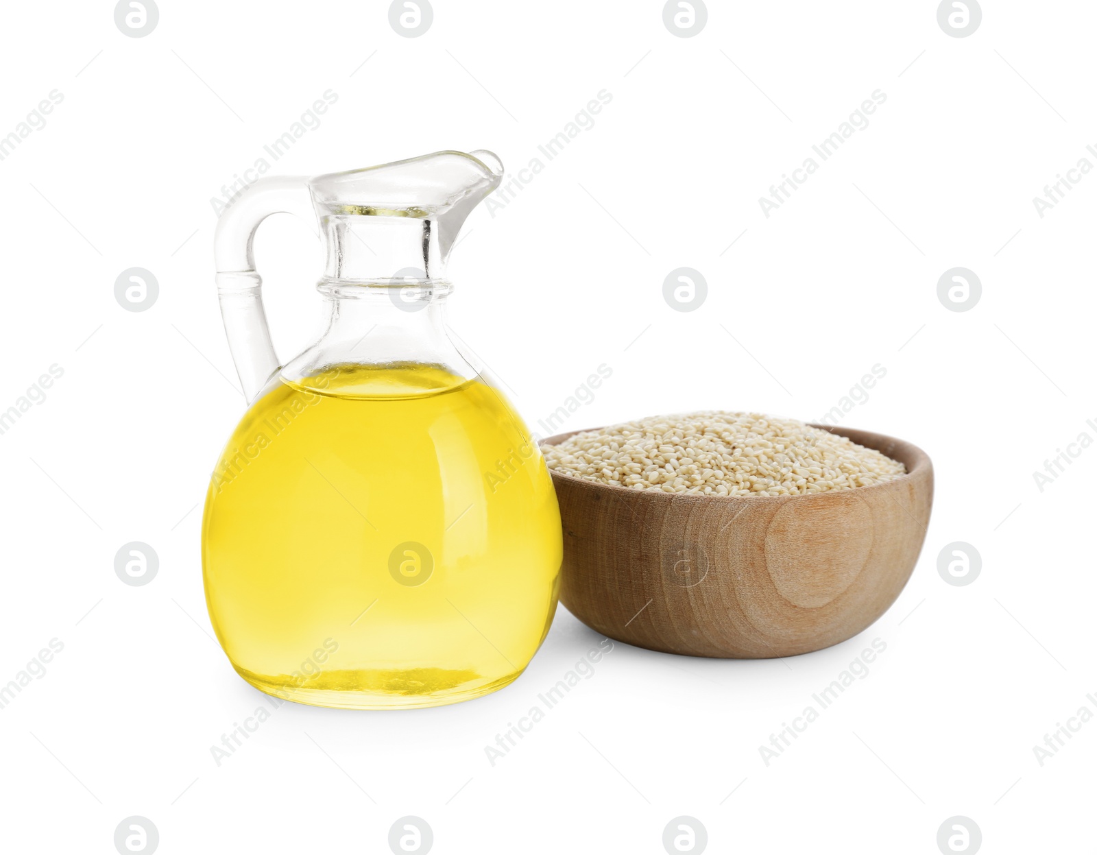 Photo of Glass jug of fresh sesame oil and bowl with seeds isolated on white