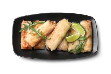 Tasty fried spring rolls, arugula and lime isolated on white, top view