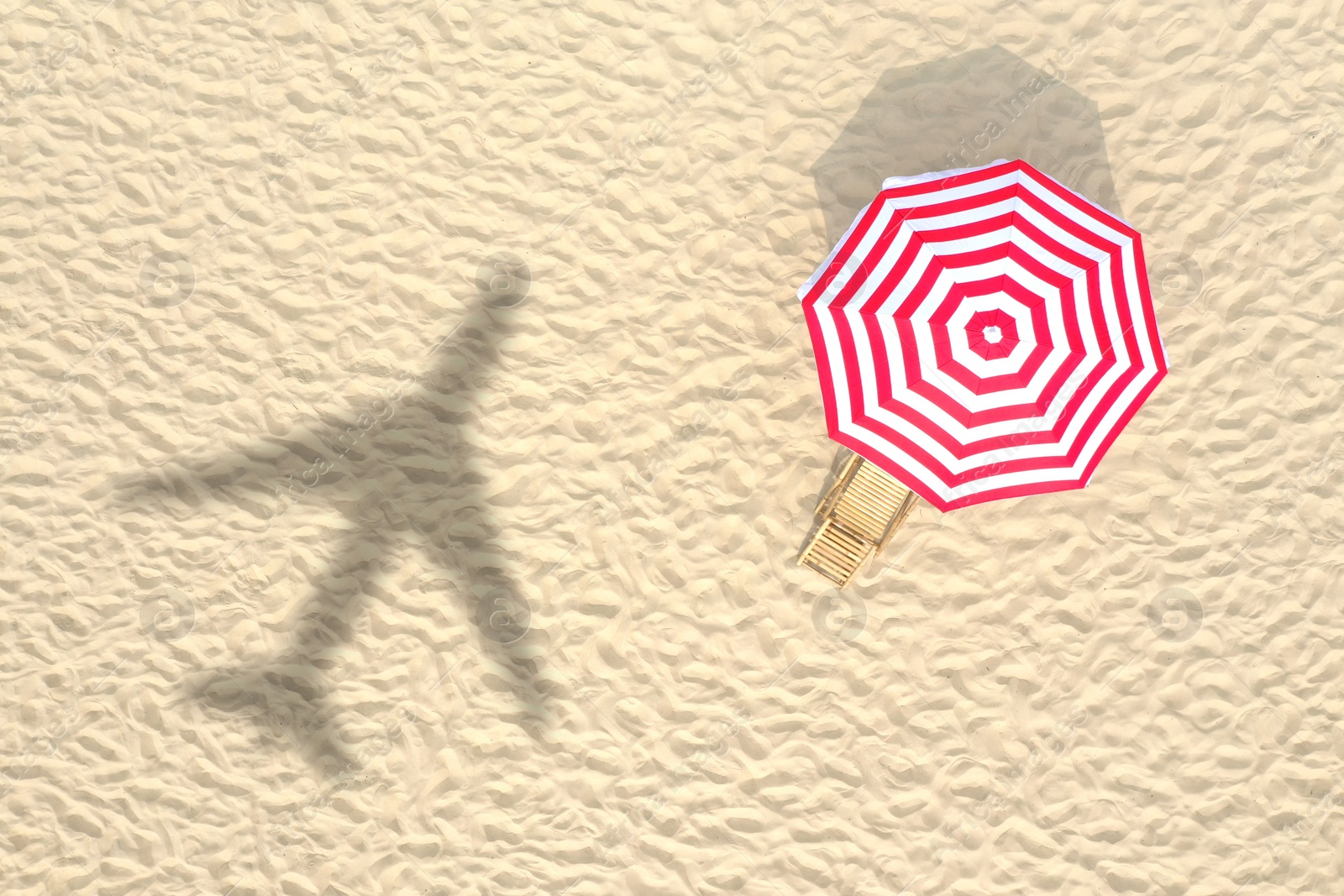 Image of Shadow of airplane above sandy coast, aerial view. Summer vacation