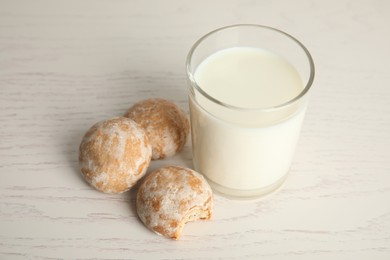 Tasty homemade gingerbread cookies and glass of milk on white wooden table