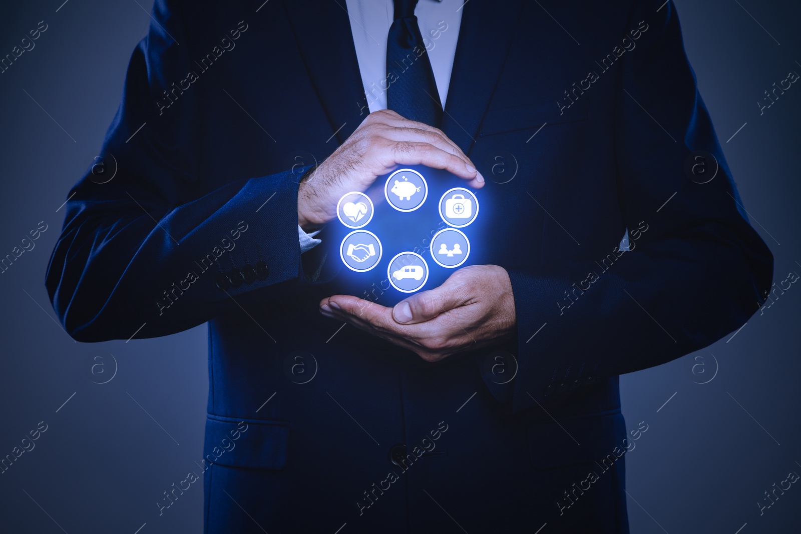 Image of Businessman holding different icons on dark background, closeup. Insurance concept