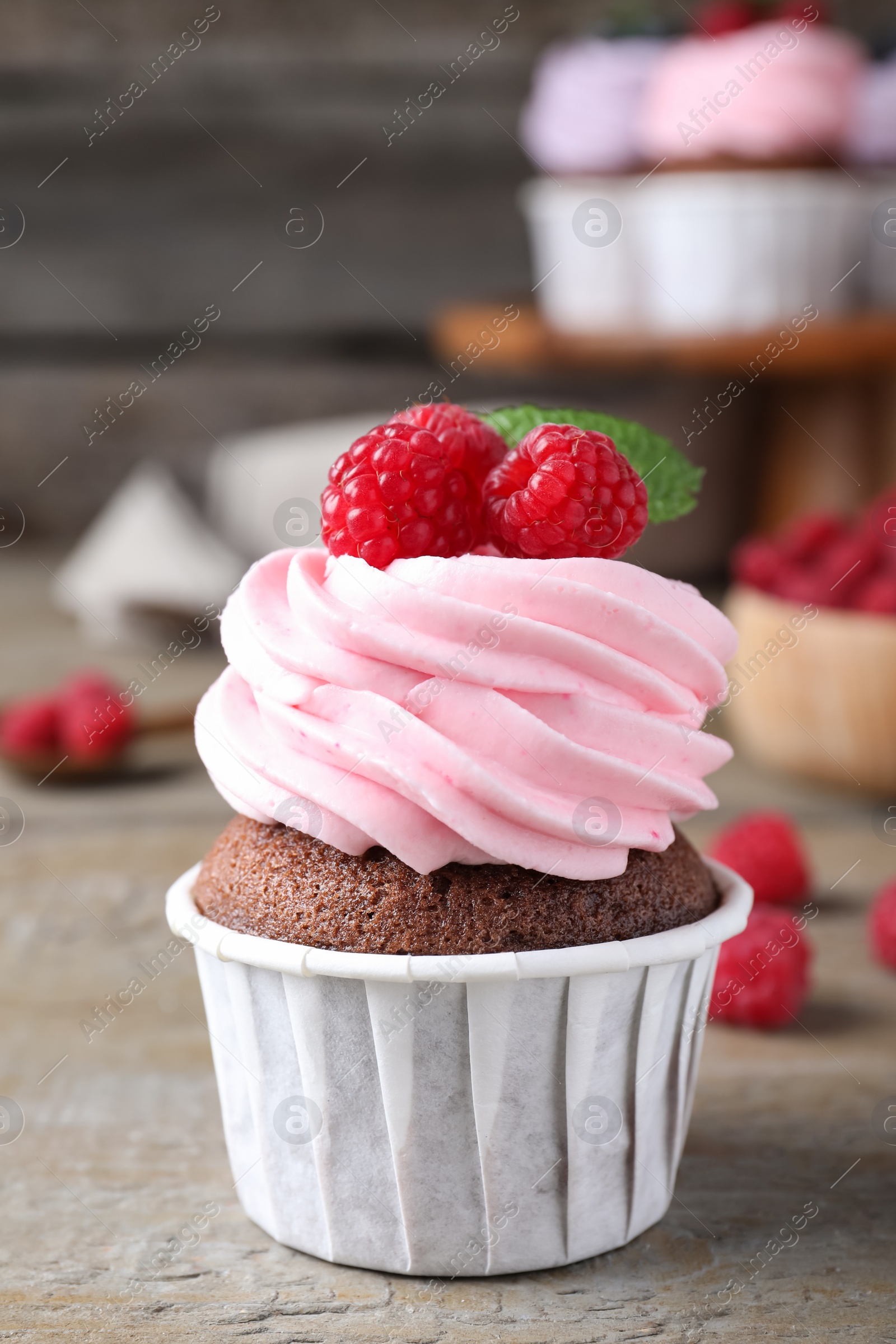 Photo of Sweet cupcake with fresh raspberries on wooden table