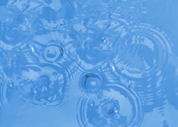 Photo of Splash of blue water with drops as background, top view