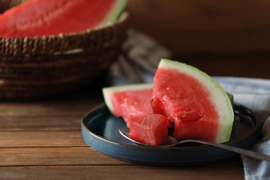 Fresh juicy watermelon and spoon on wooden table, closeup. Space for text