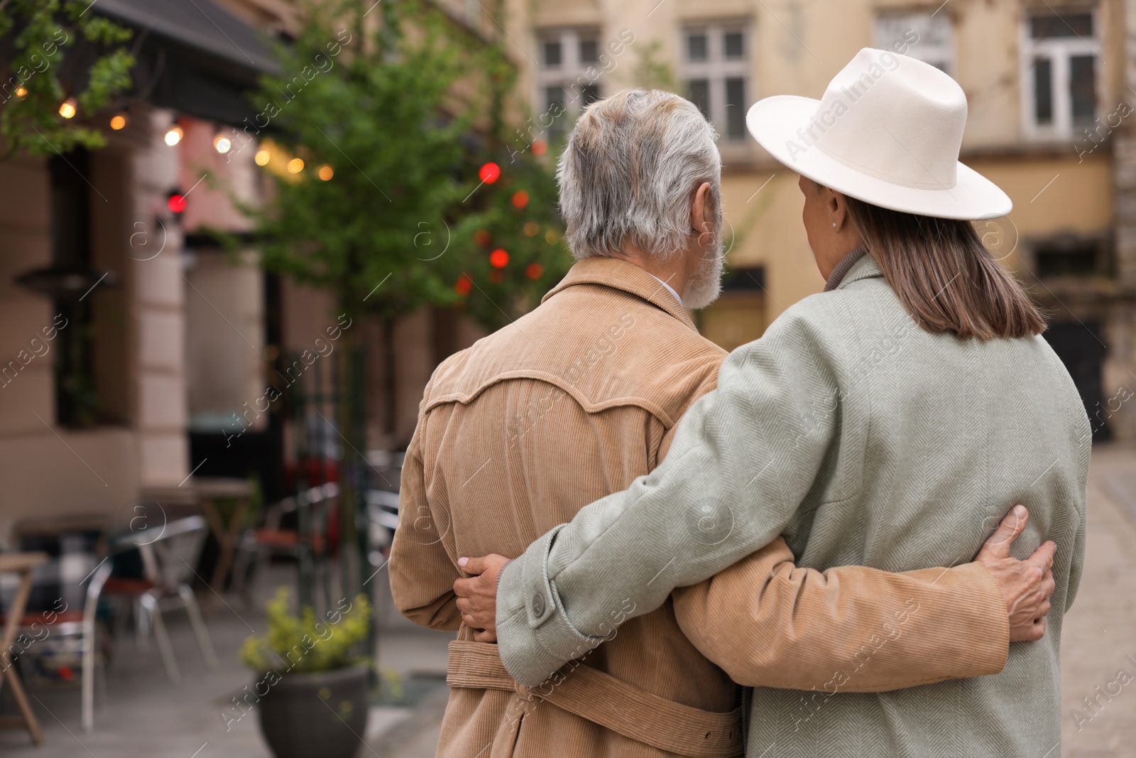 Photo of Affectionate senior couple walking outdoors, back view. Space for text