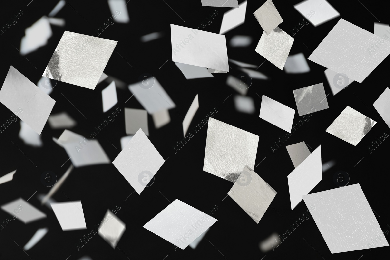 Image of White confetti falling down on black background