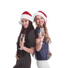 Photo of Beautiful young women in Santa hats with glasses of champagne on white background. Christmas celebration