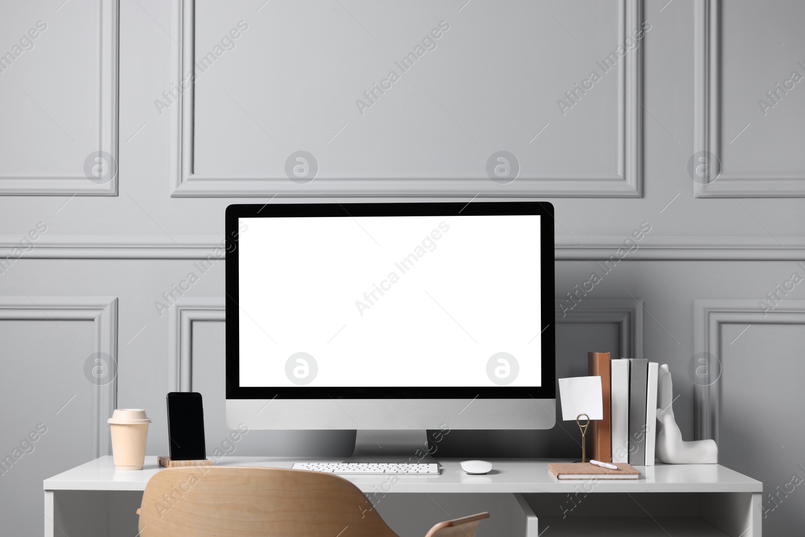 Photo of Cozy workspace with computer and stationery on white desk indoors