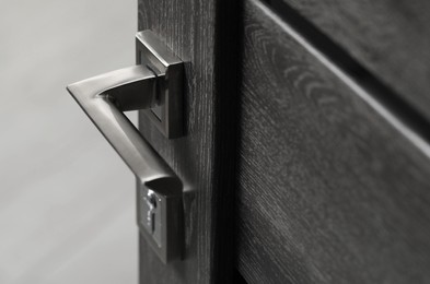 Open wooden door with metal handle, closeup