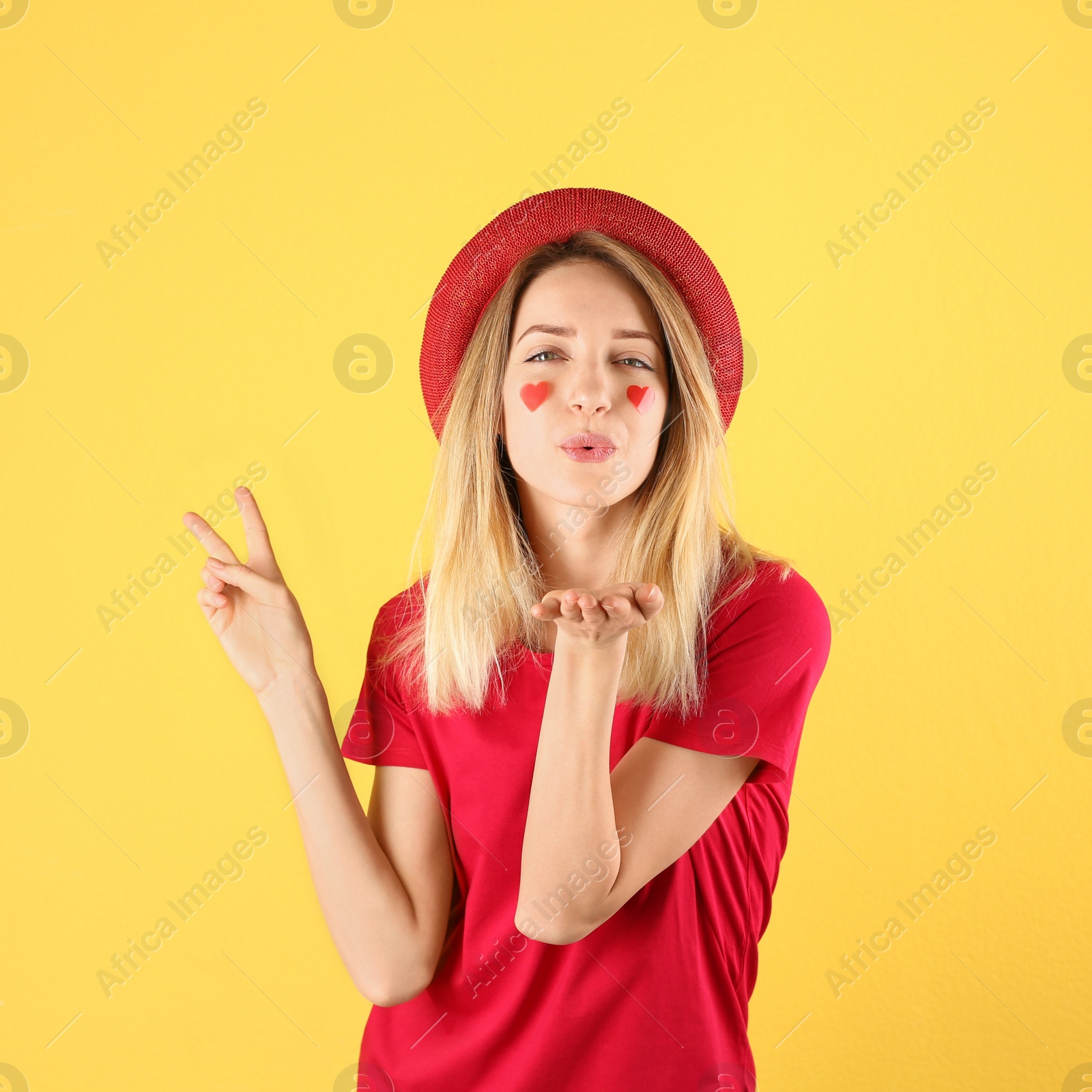 Photo of Portrait of woman with heart shaped stickers on face against color background