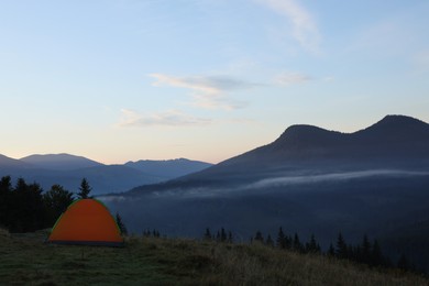 Photo of Picturesque mountain landscape with camping tent in morning