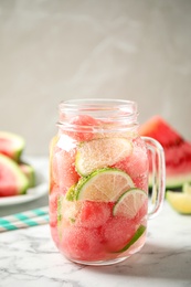 Photo of Tasty refreshing watermelon drink on marble table