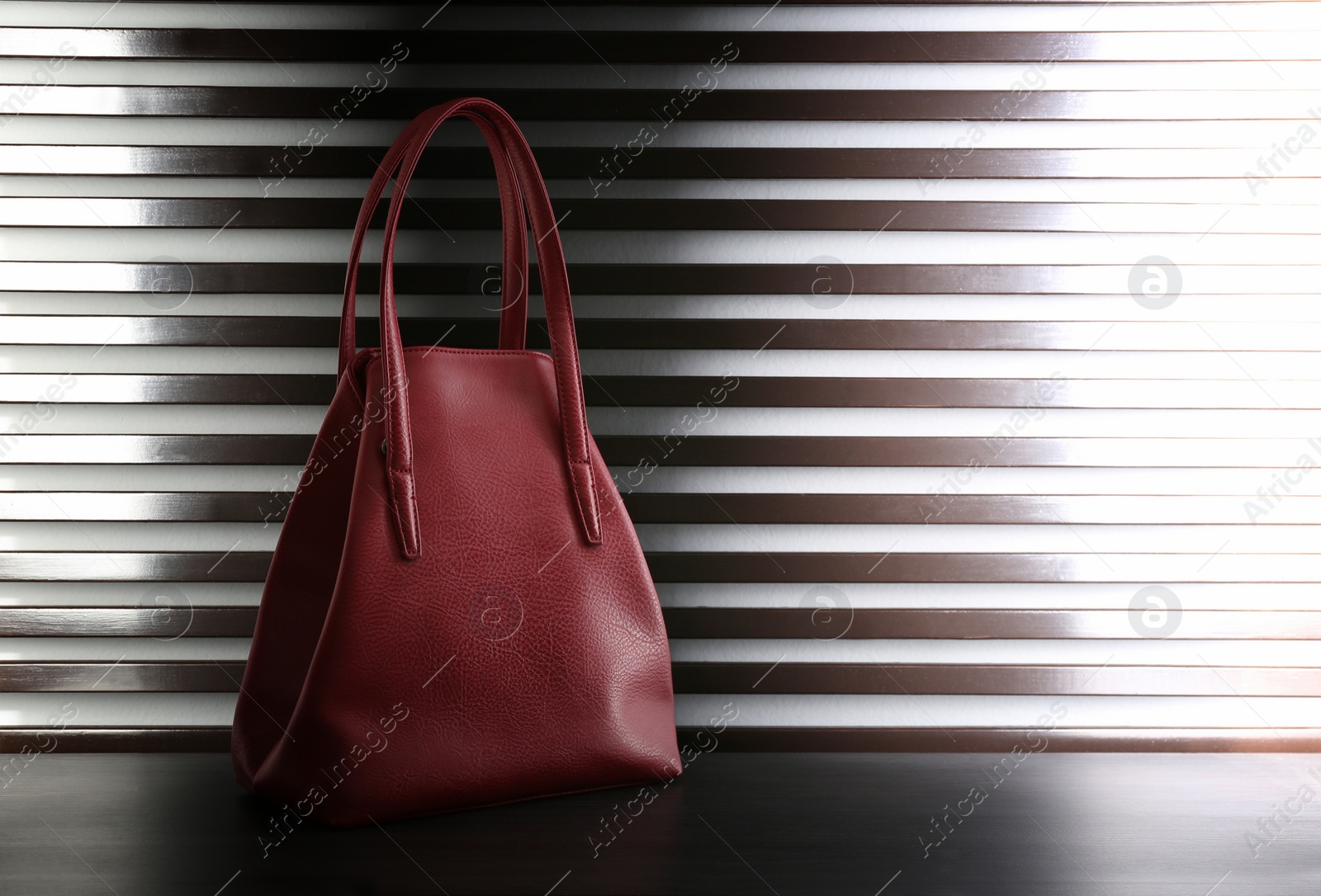 Photo of Stylish woman's bag on dark grey table. Space for text