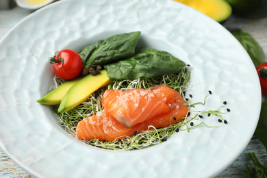 Photo of Delicious salmon with spinach served on table, closeup