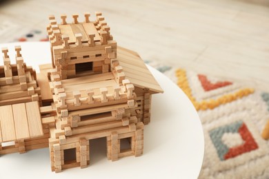 Photo of Wooden castle on white table indoors, space for text. Children's toy