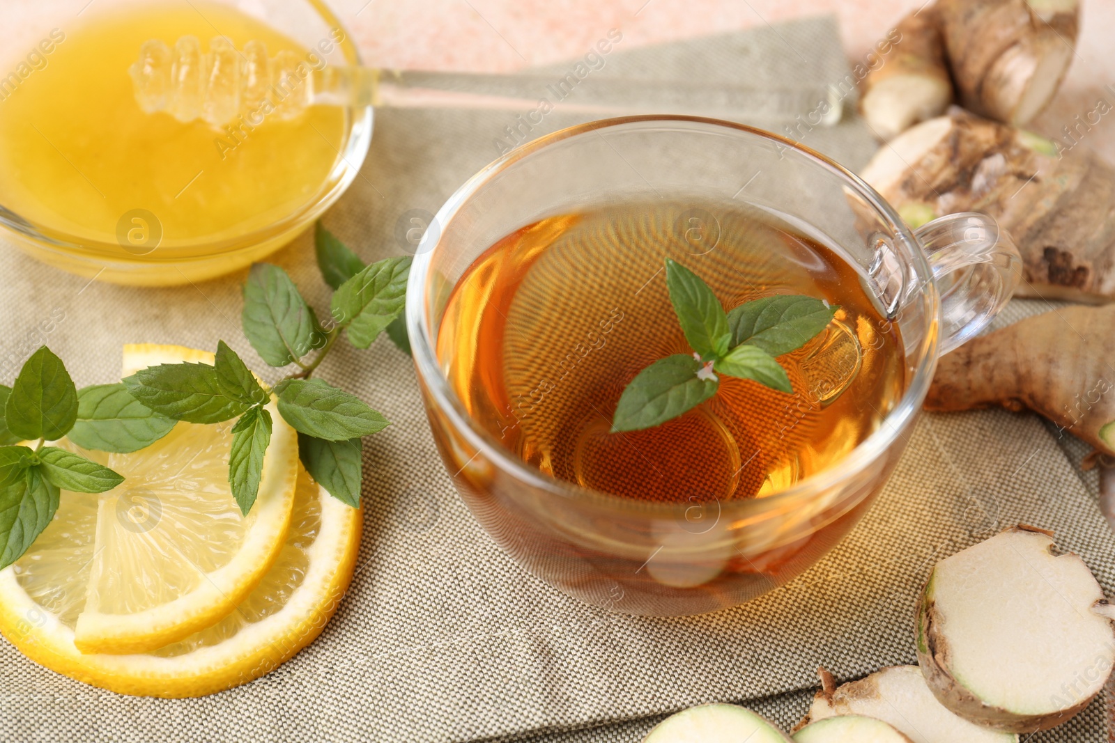 Photo of Tea with mint, honey, lemon and ginger on table, above view