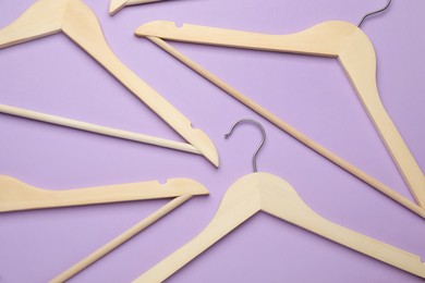 Photo of Empty clothes hangers on violet background, flat lay