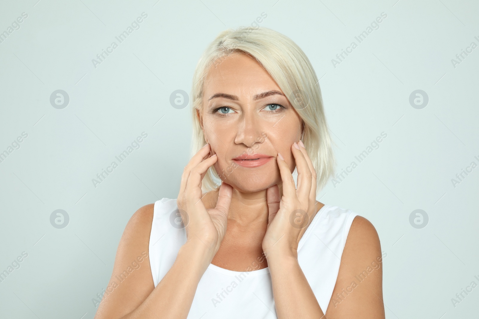 Photo of Portrait of mature woman with beautiful face on grey background