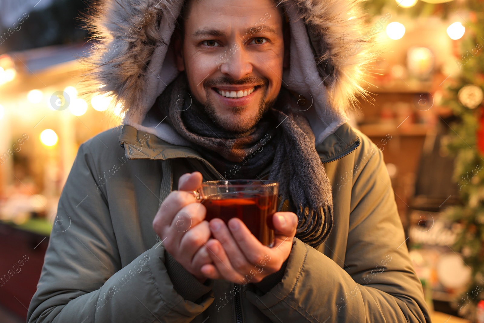 Photo of Happy man with mulled wine at winter fair