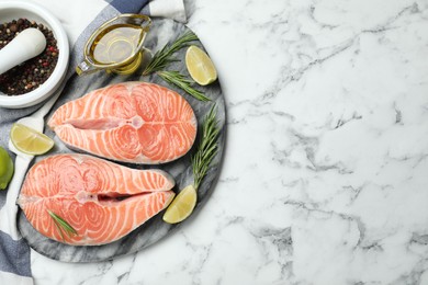 Photo of Top view of fresh raw salmon and products on white marble table, space for text. Fish delicacy