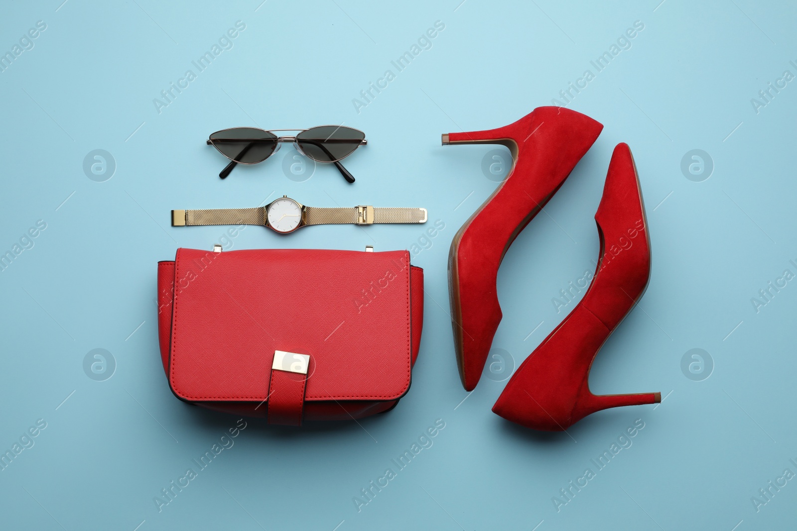 Photo of Stylish woman's bag, shoes and accessories on light blue background, flat lay