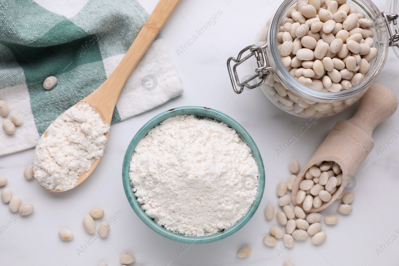 Photo of Bean flour and seeds on white marble table, flat lay