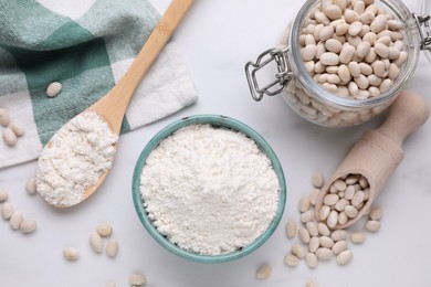 Photo of Bean flour and seeds on white marble table, flat lay