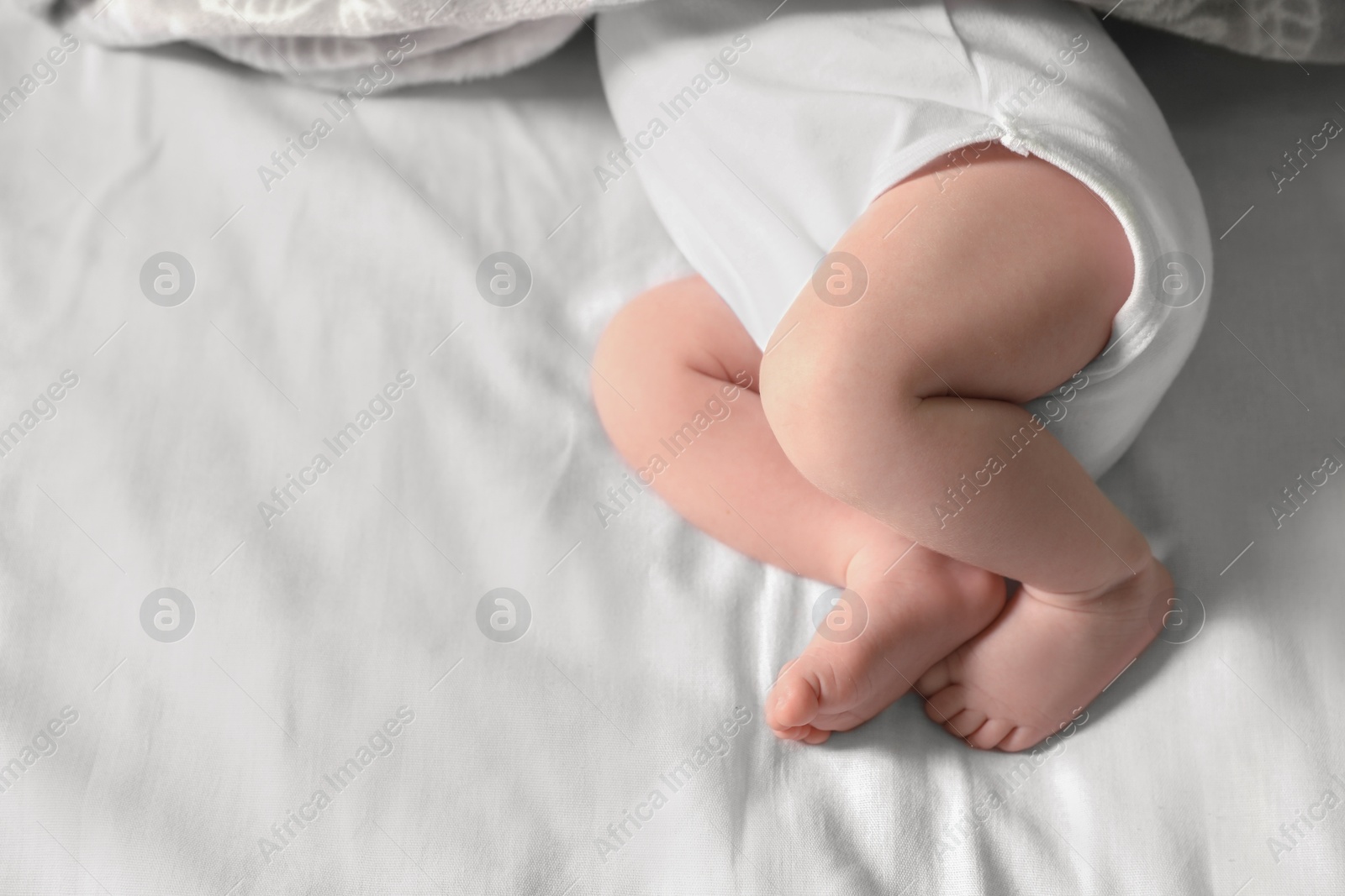 Photo of Little baby lying on bed, closeup view