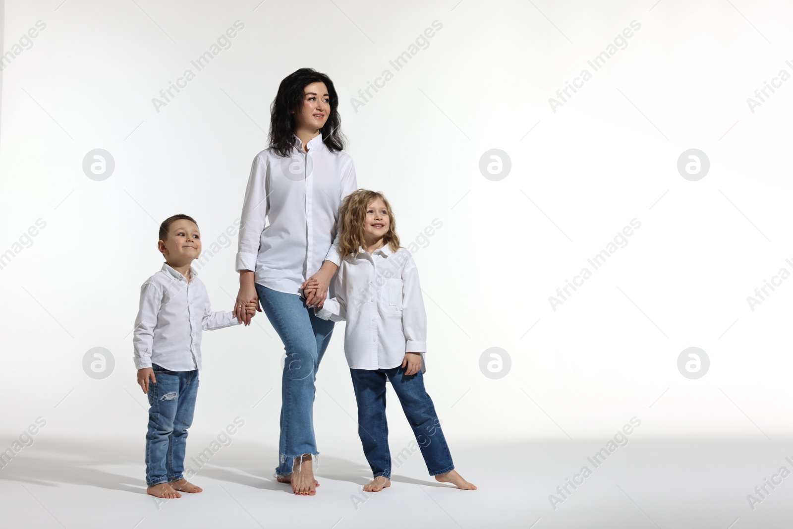 Photo of Little children with their mother on white background. Space for text