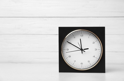Photo of Modern clock on table against light background. Time management