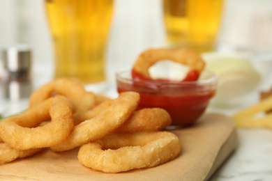 Fried onion rings with sauce served on table, closeup