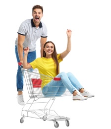 Young couple with shopping cart on white background