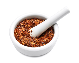 Photo of Mortar with crushed chili pepper on white background