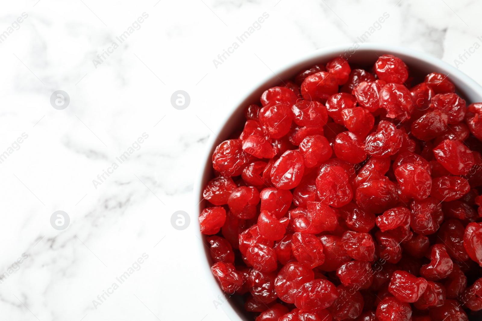 Photo of Bowl of sweet cherries on marble background, top view with space for text. Dried fruit as healthy snack