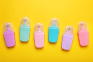 Photo of Many colorful markers on yellow background, flat lay