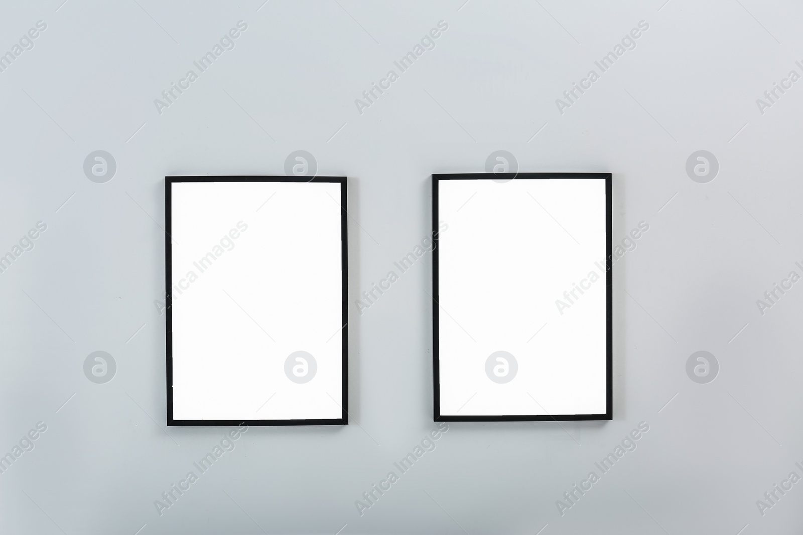 Photo of Frames with empty canvases on wall in modern art gallery. Mockup for design