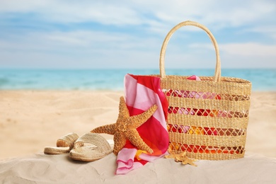 Image of Different beach accessories on sand near ocean