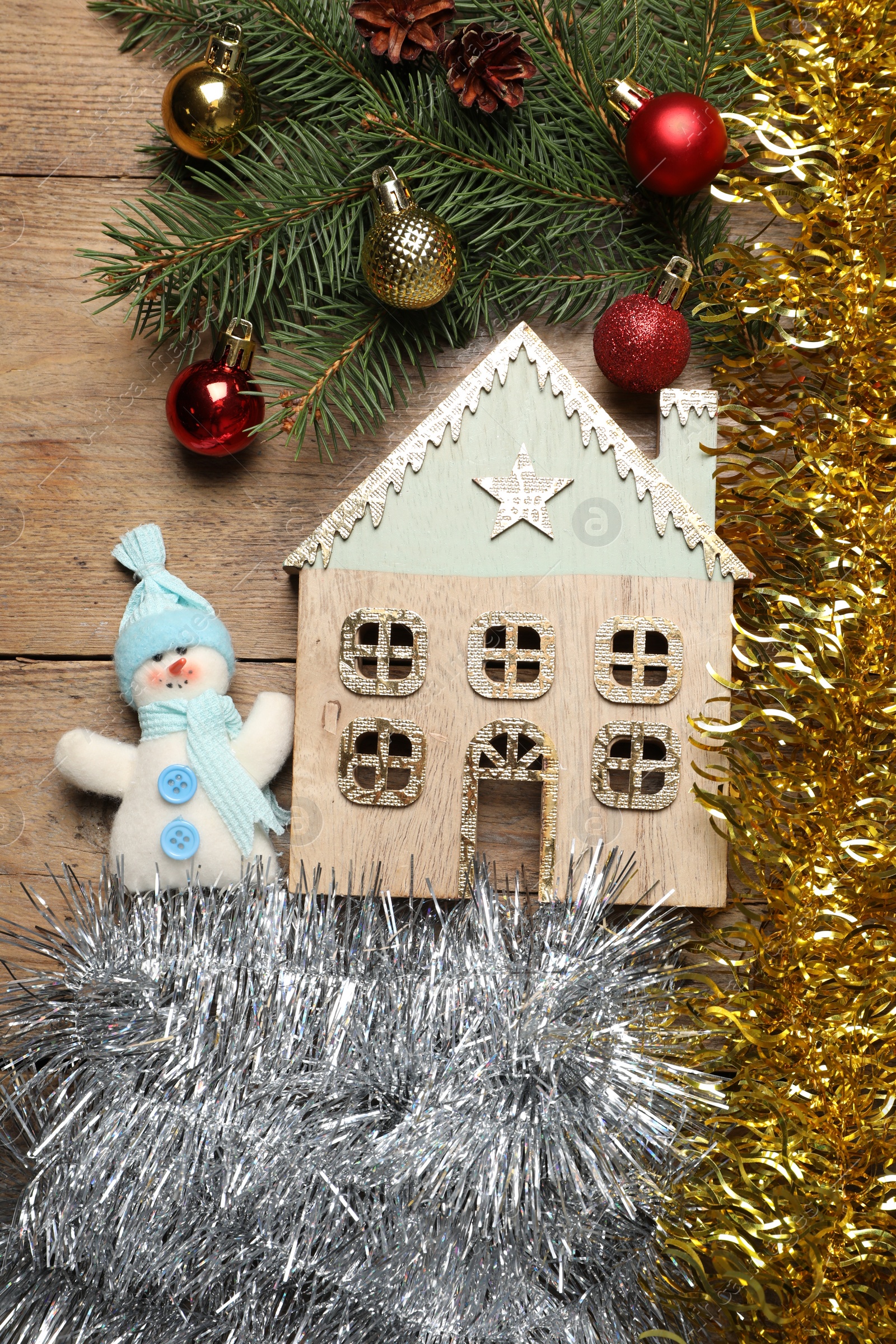 Photo of Bright tinsel, fir tree branches and Christmas decor on wooden background, flat lay