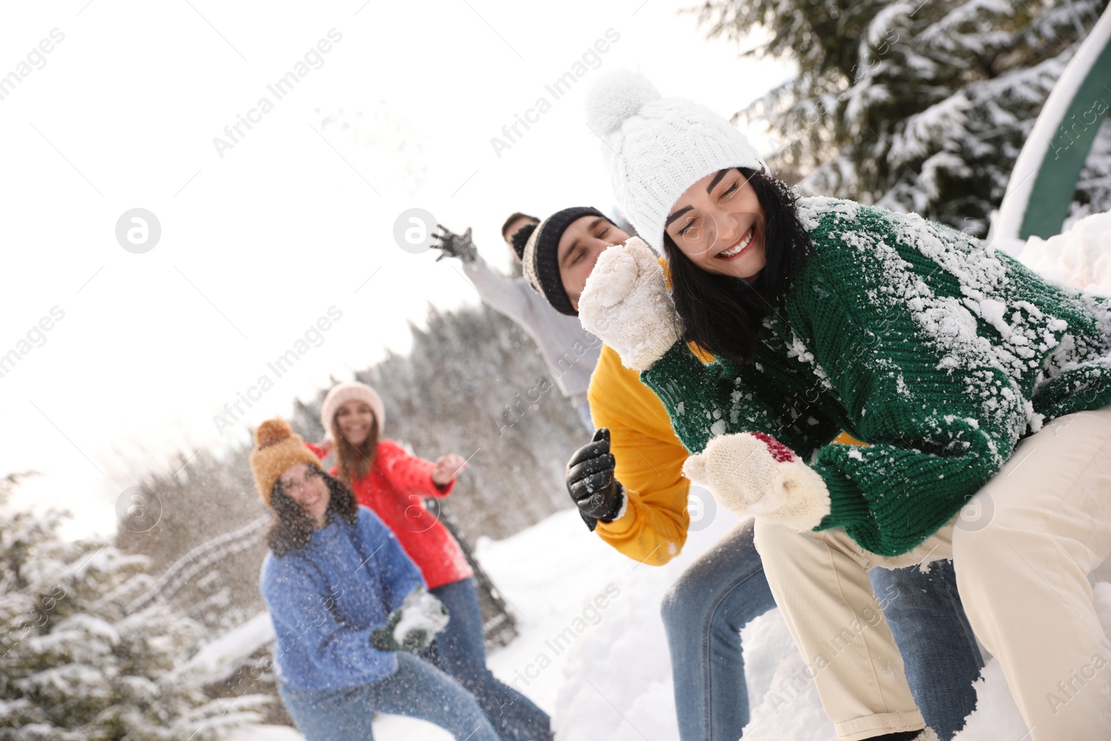 Photo of Group of friends playing snowballs outdoors. Winter vacation