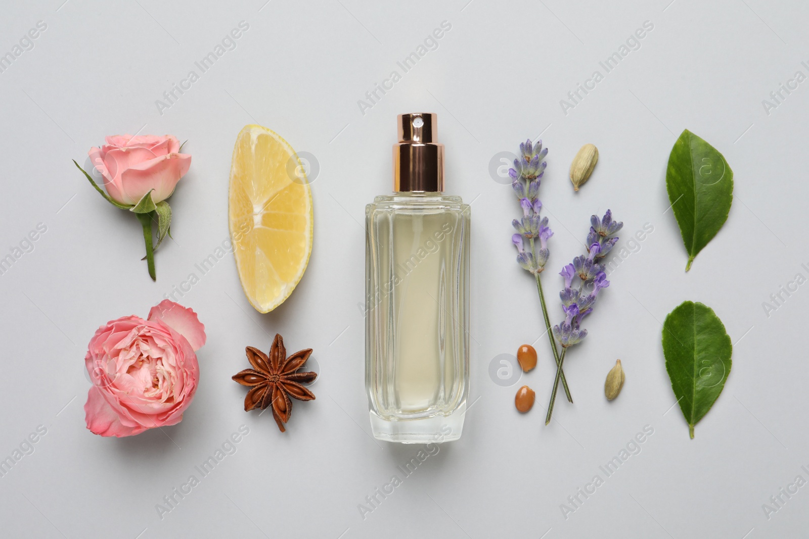 Photo of Flat lay composition with bottle of perfume, lemon and flowers on light grey background