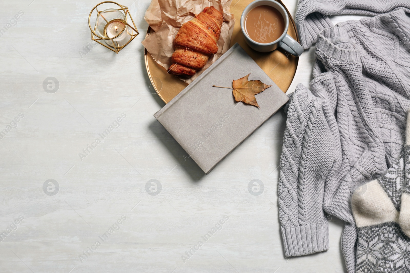 Photo of Flat lay composition with warm sweater and space for text on light background