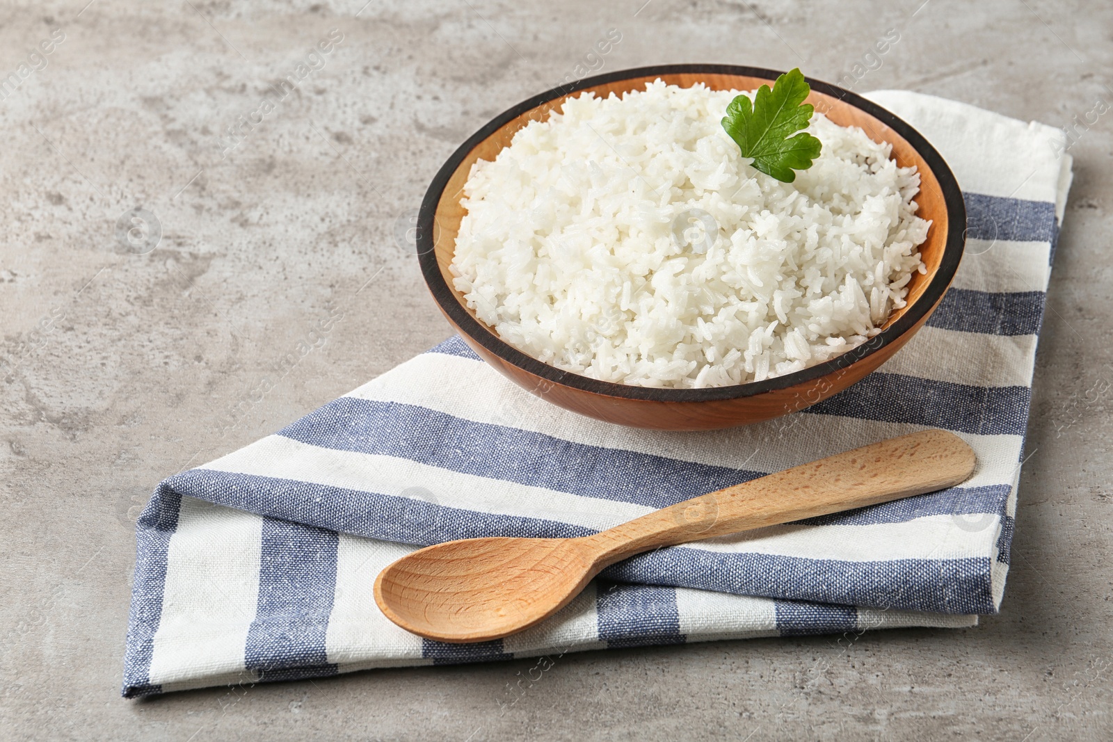 Photo of Bowl of boiled rice and spoon on table