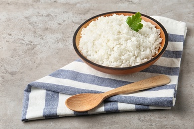 Photo of Bowl of boiled rice and spoon on table