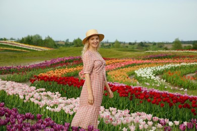 Happy woman in beautiful tulip field outdoors