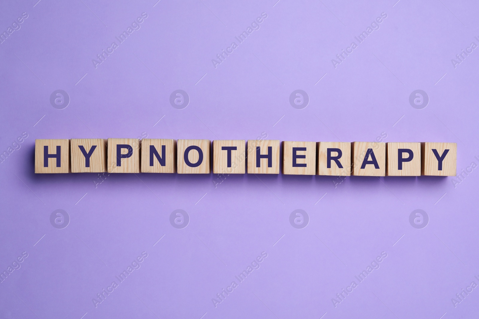 Photo of Wooden blocks with word HYPNOTHERAPY on violet background, flat lay