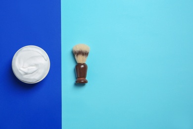 Flat lay composition with shaving brush and cream on color background. Space for text