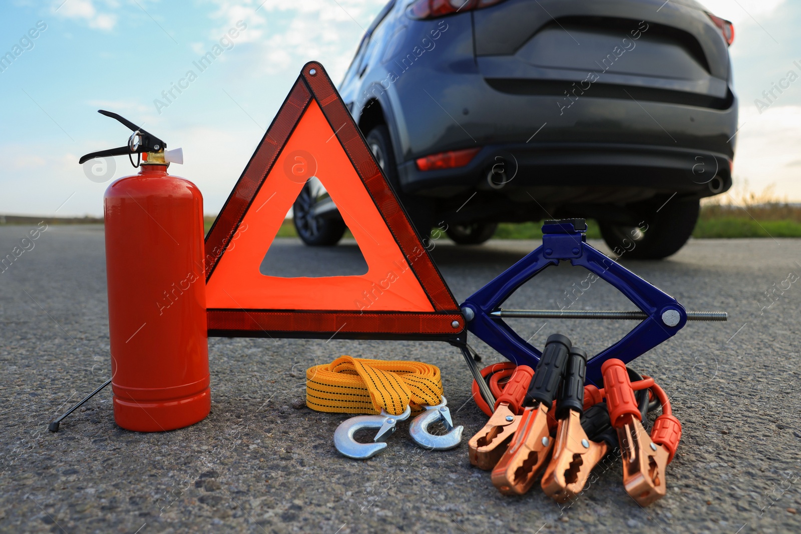 Photo of Emergency warning triangle and car safety equipment outdoors